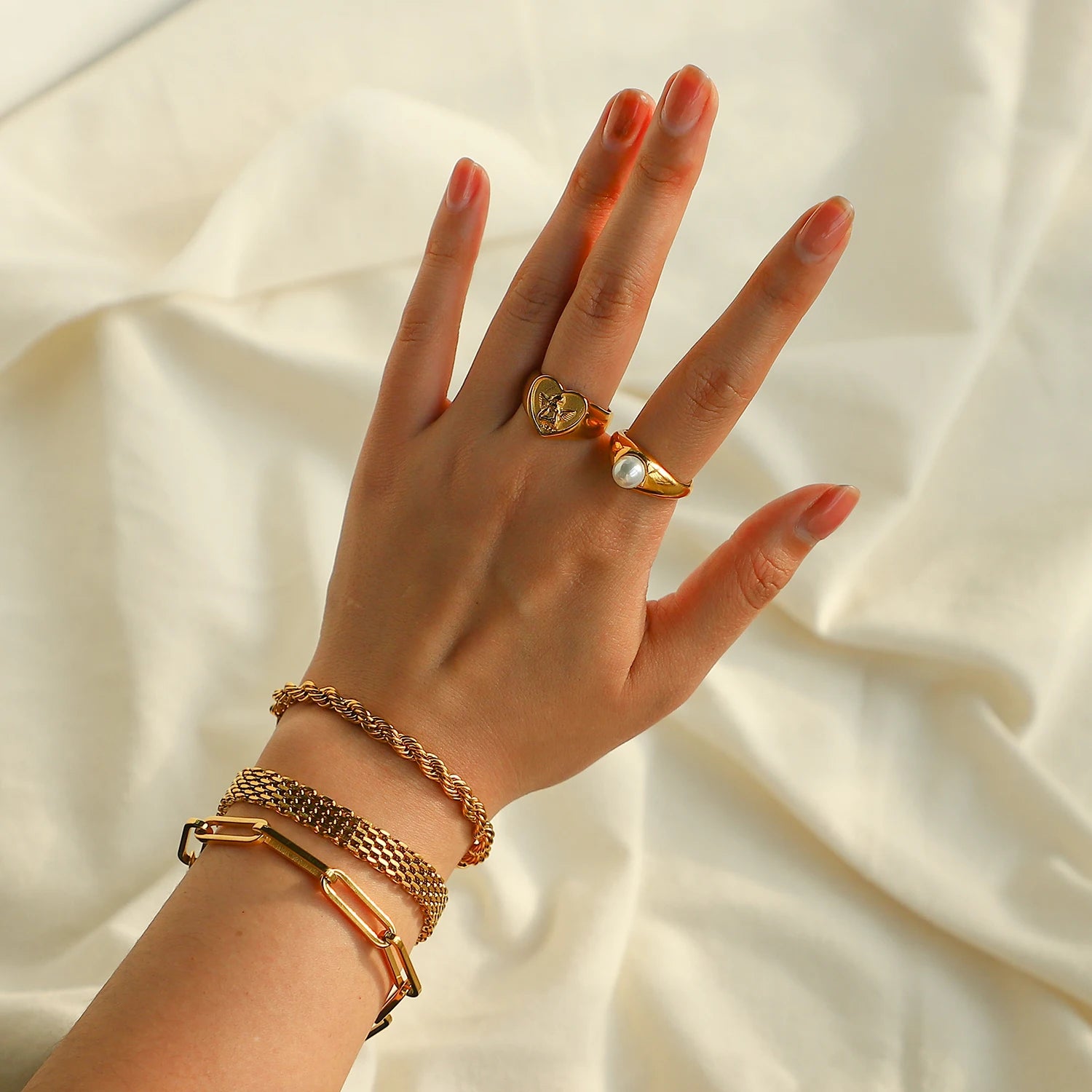 A chunky 18ct gold plated medical steel heart signet ring featuring a detailed embossed cherub (angel) on a textured gold background.