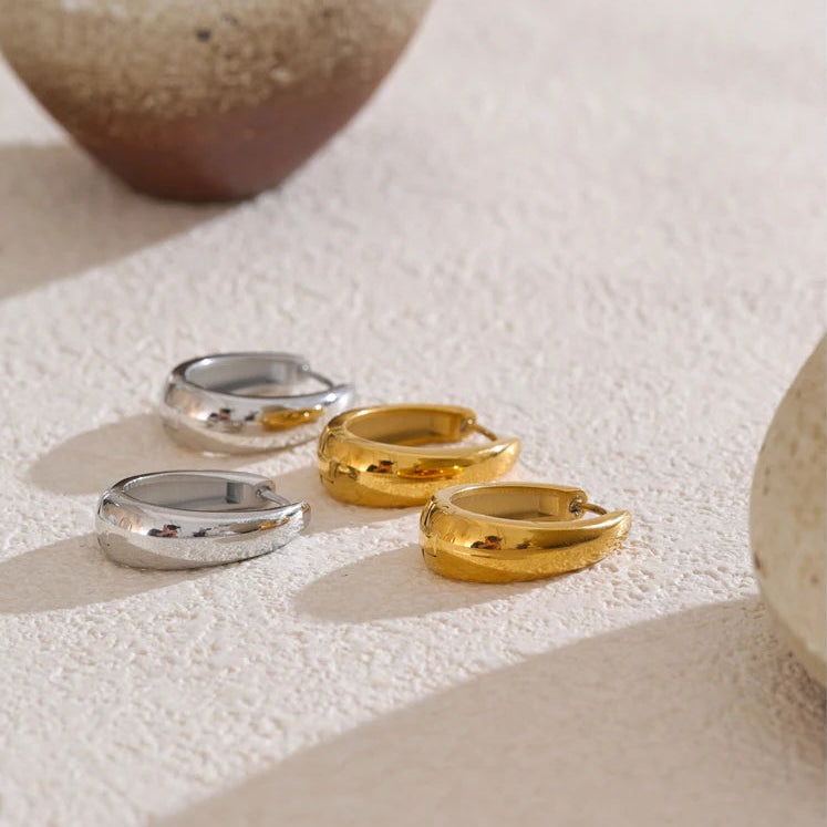 A pair of 18ct gold plated medical steel huggie hoop earrings featuring four interlocking bands, two plain gold and two with clear crystal pavé, creating a stacked look.