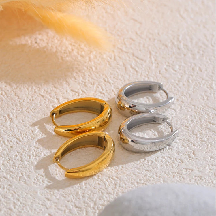 A pair of 18ct gold plated medical steel huggie hoop earrings featuring four interlocking bands, two plain gold and two with clear crystal pavé, creating a stacked look.