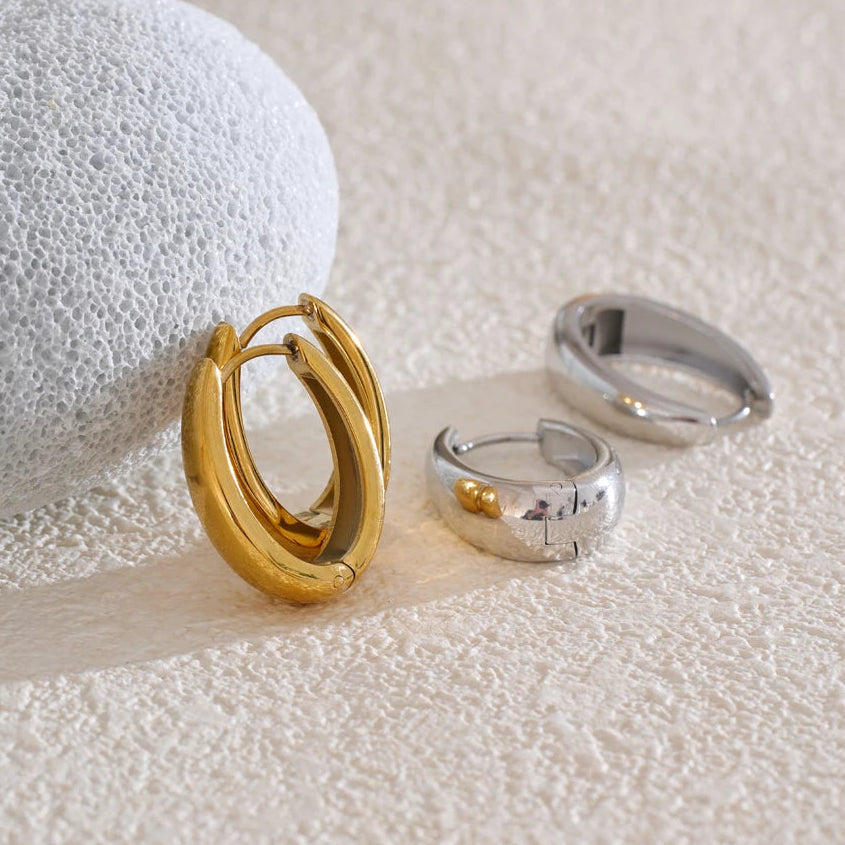 A pair of 18ct gold plated medical steel huggie hoop earrings featuring four interlocking bands, two plain gold and two with clear crystal pavé, creating a stacked look.