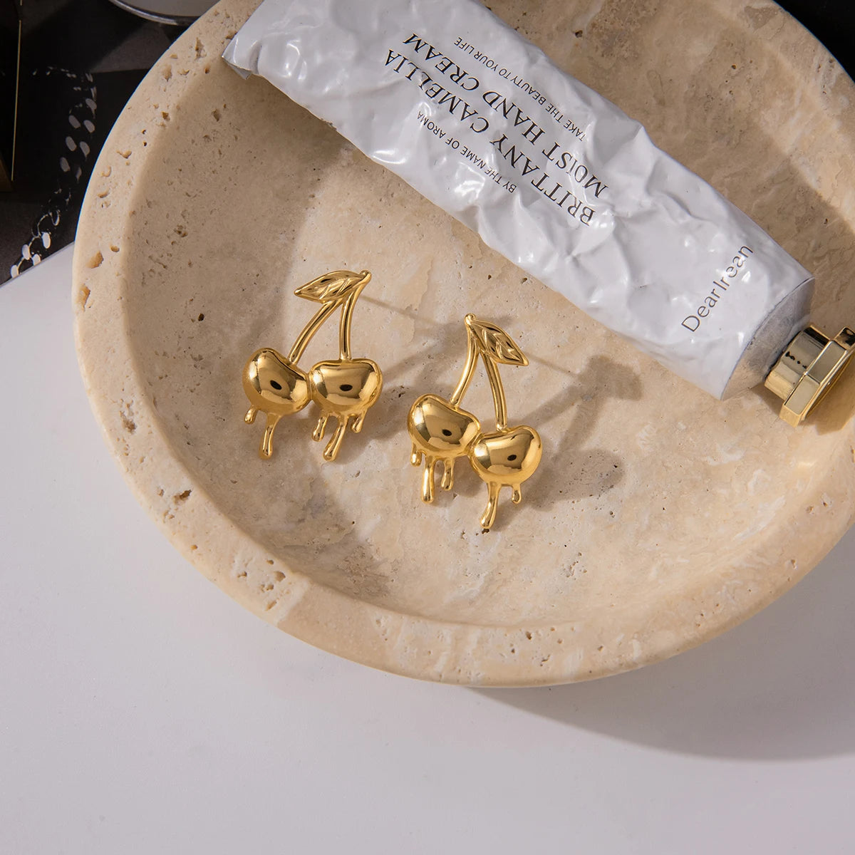 Gold-plated medical steel drop earrings in the shape of cherries with a unique melting or dripping gold effect. High-shine finish, hypoallergenic and waterproof.