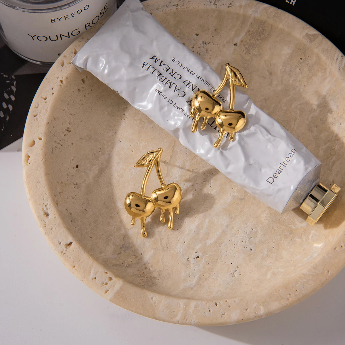 Gold-plated medical steel drop earrings in the shape of cherries with a unique melting or dripping gold effect. High-shine finish, hypoallergenic and waterproof.