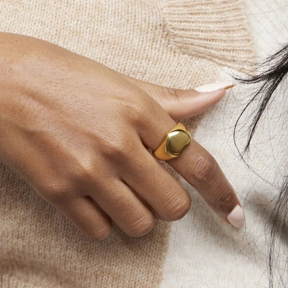A chunky 18ct gold plated medical steel signet ring featuring a large, polished heart-shaped face. High-shine finish, hypoallergenic and tarnish-resistant.