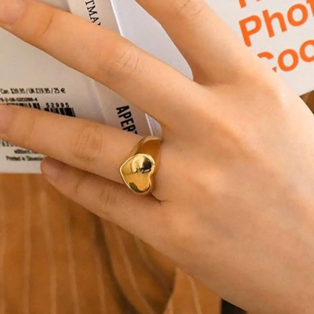 A chunky 18ct gold plated medical steel signet ring featuring a large, polished heart-shaped face. High-shine finish, hypoallergenic and tarnish-resistant.