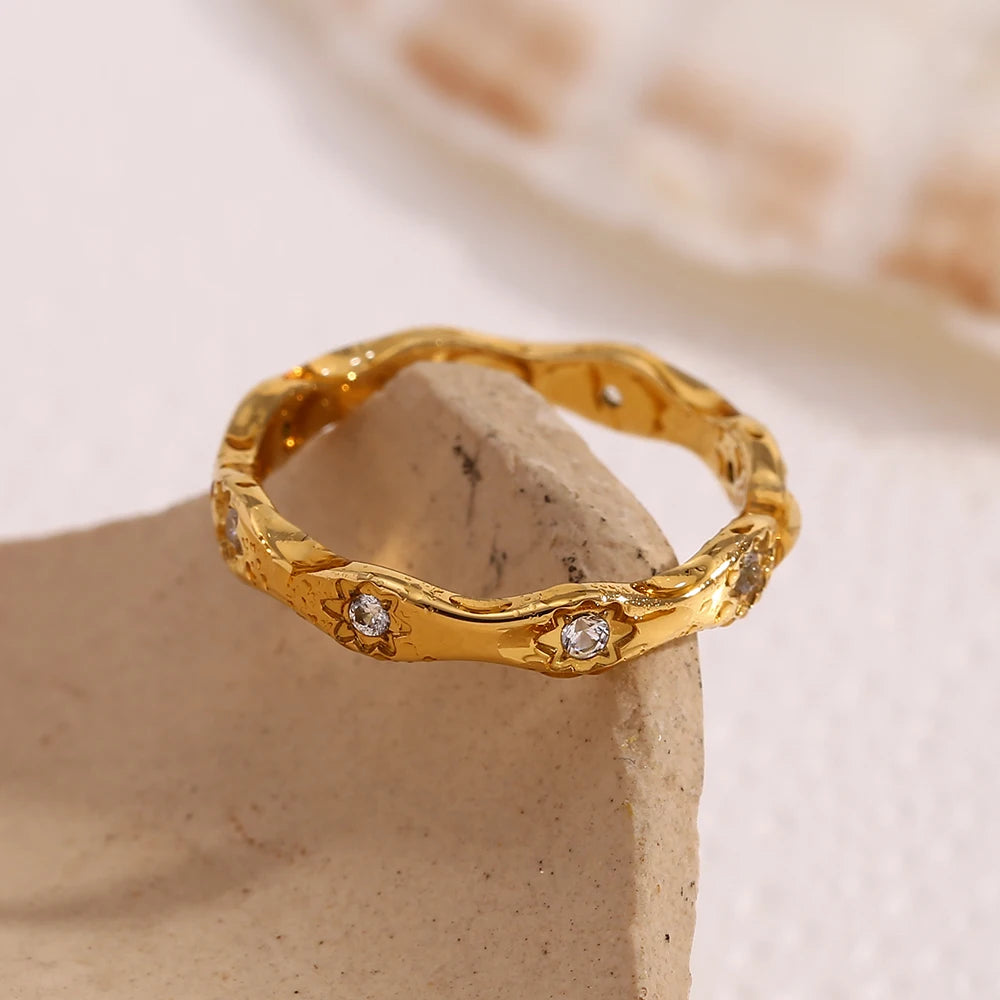 Celestial-inspired wavy stacking ring crafted from hypoallergenic 18k gold plated stainless steel. Polished finish with starry crystal accents.