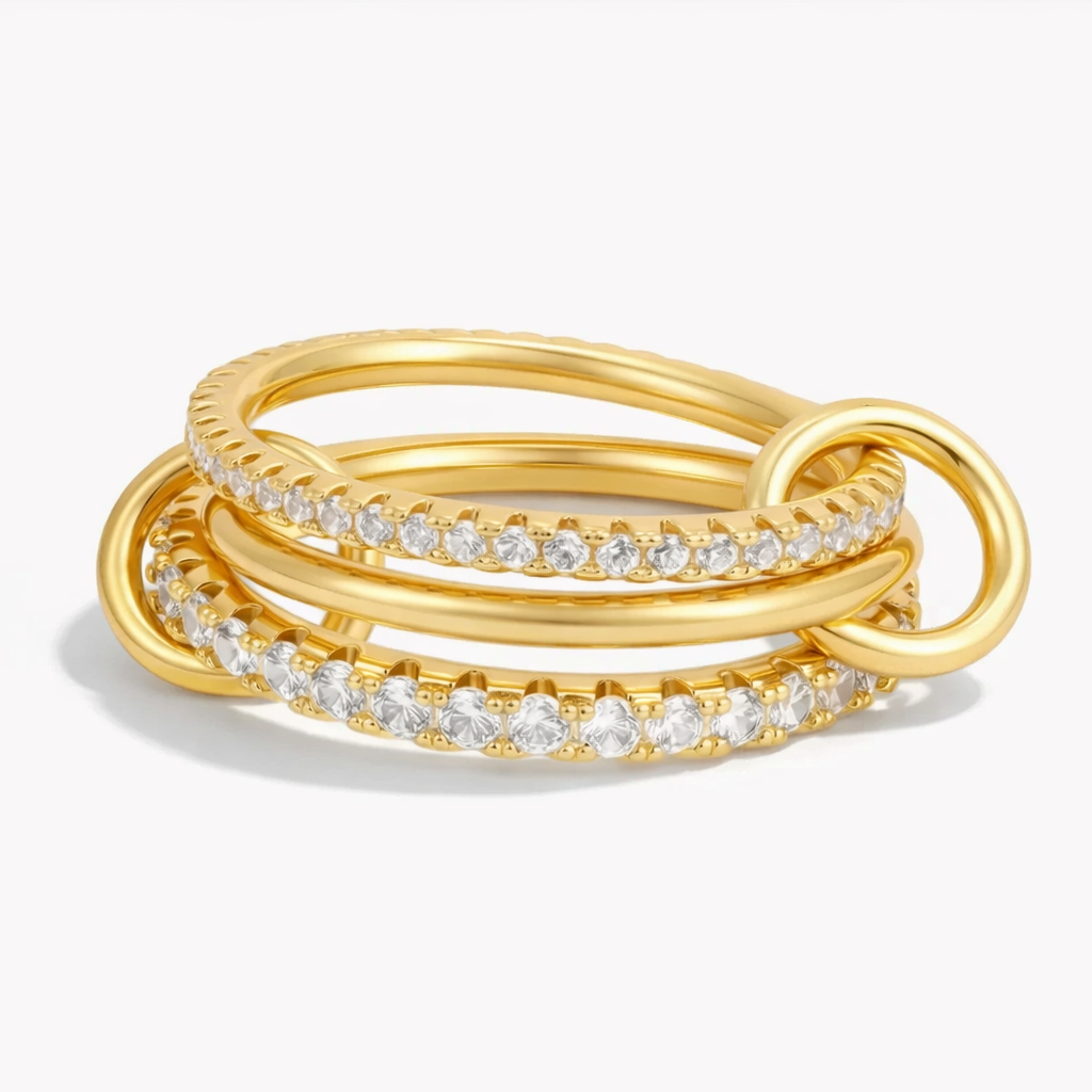 Interconnected 18k gold plated medical steel multi-band ring featuring two pave-set eternity bands with clear diamantes and a smooth central band, linked by two polished gold loops.