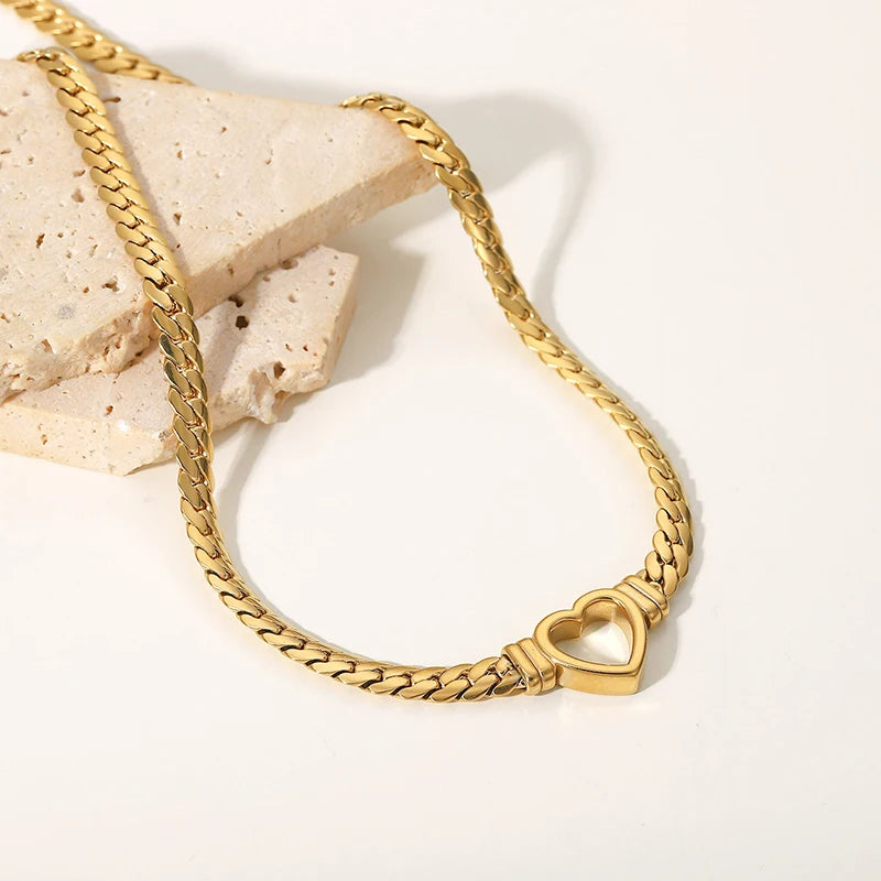 Gold chain bracelet with a heart clasp on a light background
