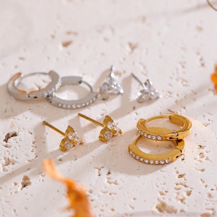 Set of gold and silver earrings on a textured surface