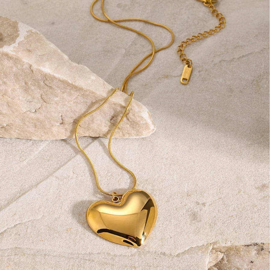 Gold heart-shaped necklace on a marble surface