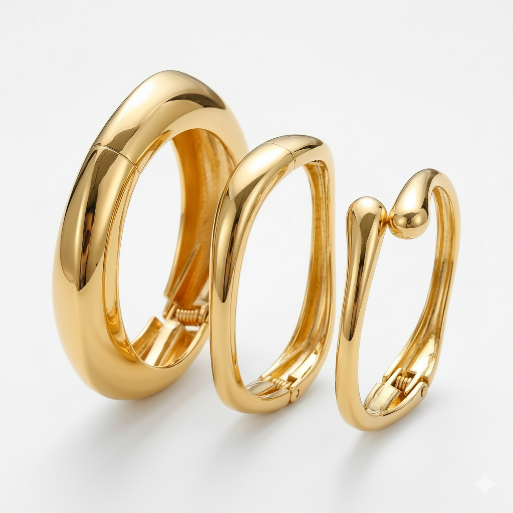 Three chunky gold-finish stackable bangles with a smooth, high-shine surface and unique curved design, displayed against a white background.
