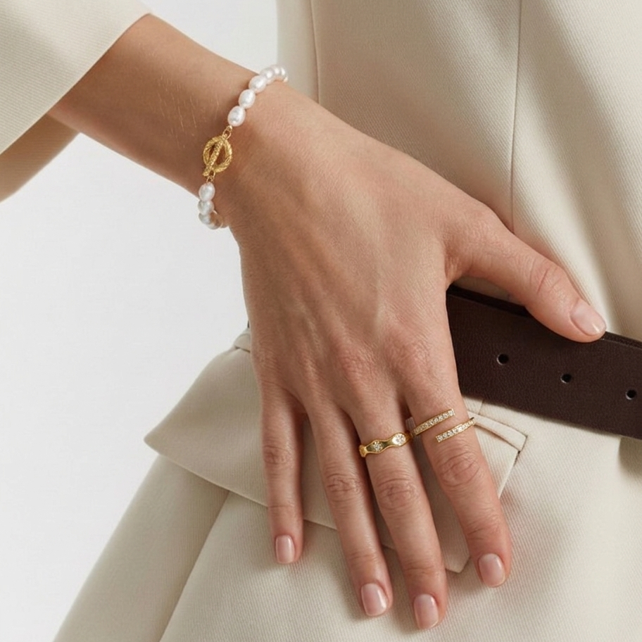 A multi-strand choker necklace featuring five rows of delicate white seed pearls and a central 18ct gold plated medical steel floral motif with an iridescent stone centre.