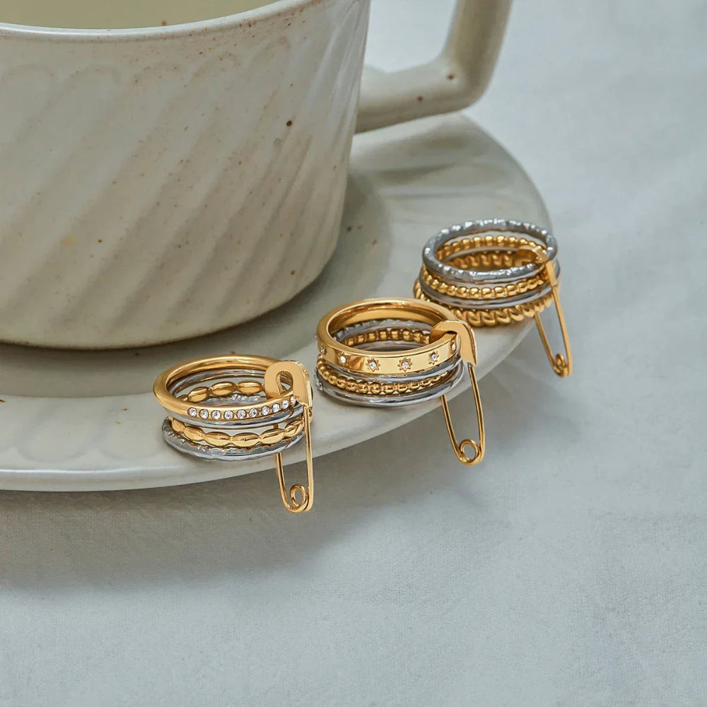 Edgy mixed-metal jewellery piece: a chunky stacking ring with diamante detailing and a statement gold safety pin clasp.