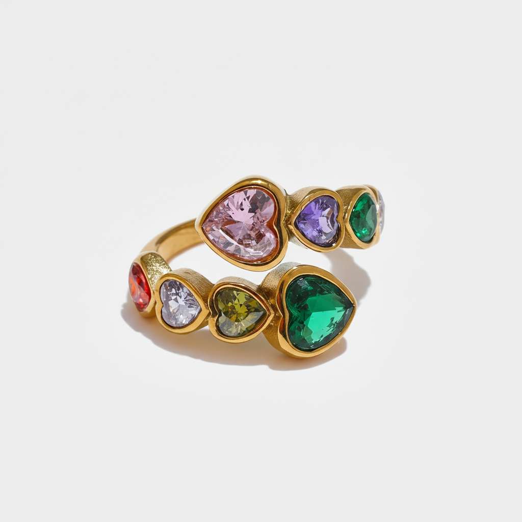 A gold-tone wrap ring featuring a bypass design set with multi-coloured heart-shaped crystals, including pink, purple, emerald green, and amber tones.
