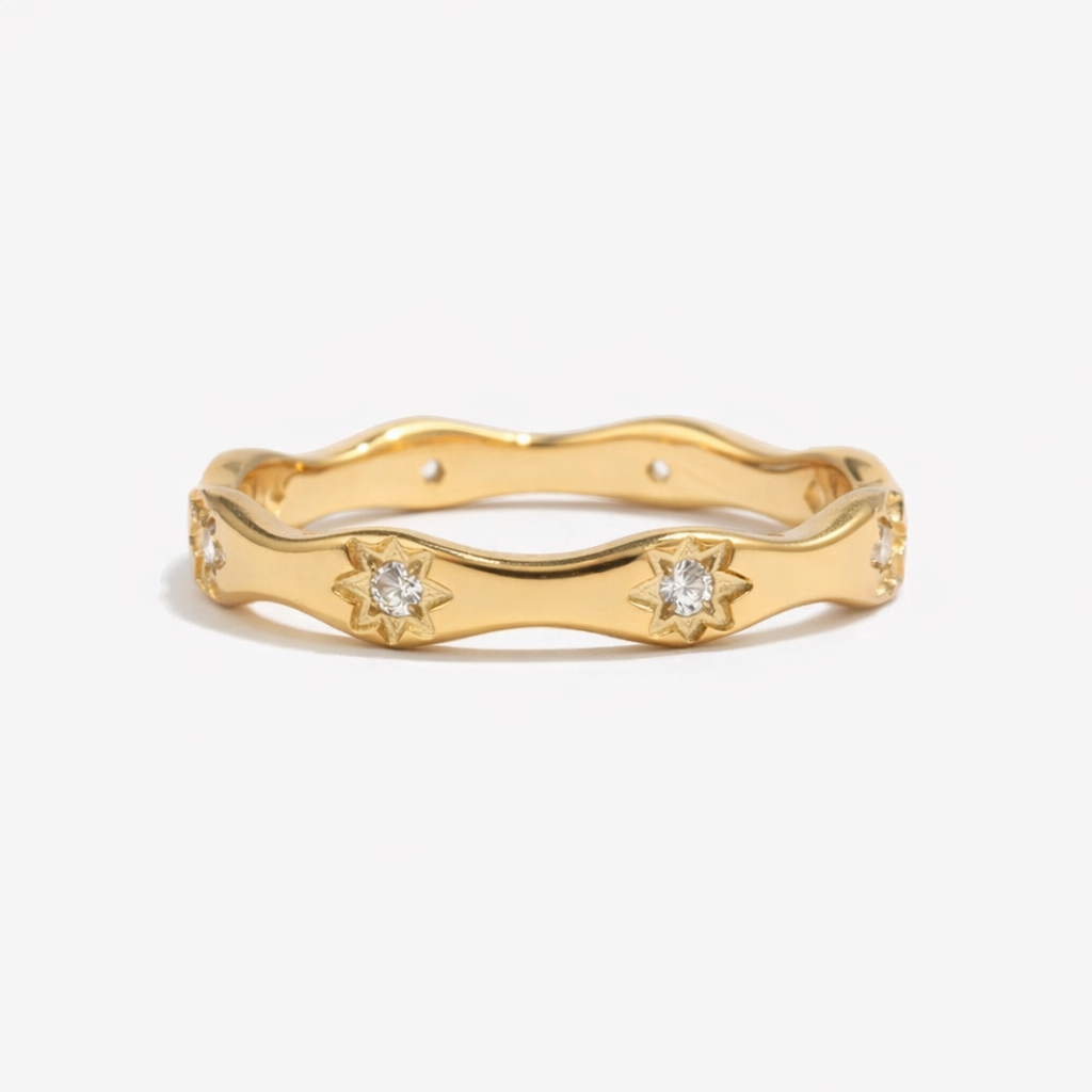Celestial-inspired wavy stacking ring crafted from hypoallergenic 18k gold plated stainless steel. Polished finish with starry crystal accents.