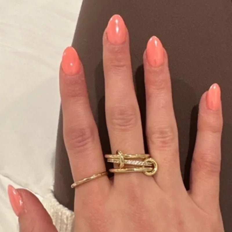 Interconnected 18k gold plated medical steel multi-band ring featuring two pave-set eternity bands with clear diamantes and a smooth central band, linked by two polished gold loops.