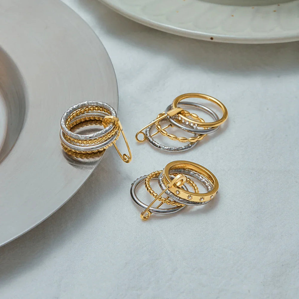 Edgy mixed-metal jewellery piece: a chunky stacking ring with diamante detailing and a statement gold safety pin clasp.