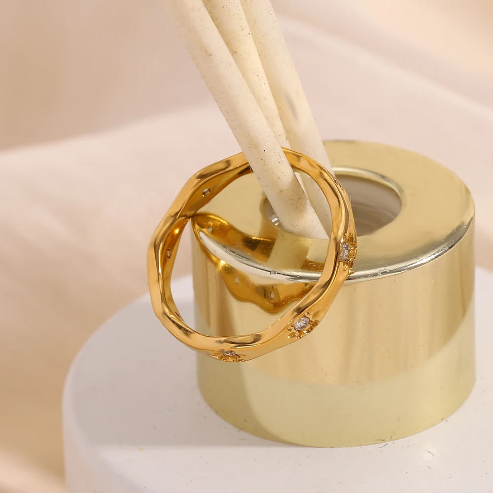 An organically-textured 18ct gold plated medical steel wavy ring, featuring starburst engravings set with clear diamantes (crystals).