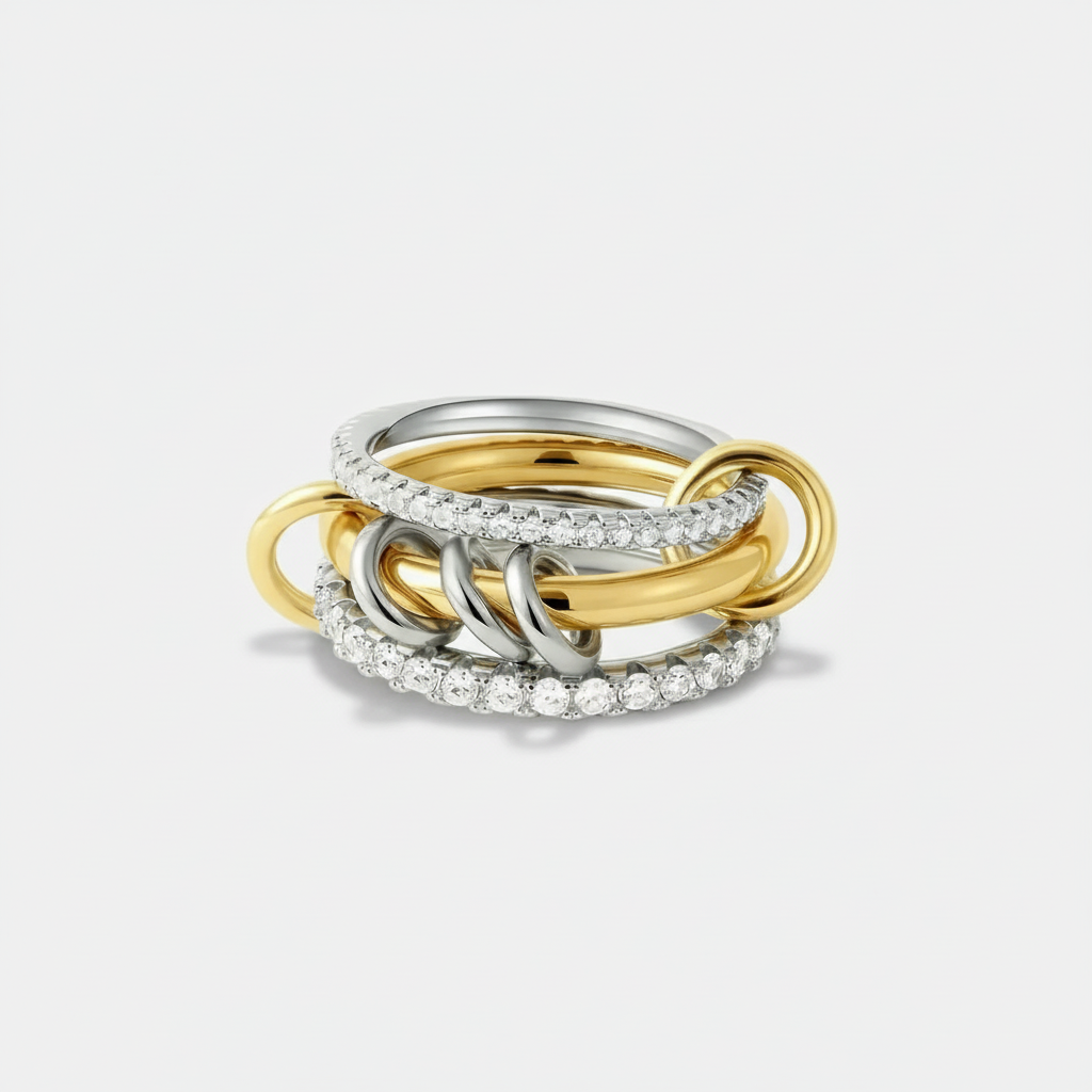 Exquisite interlocking mixed-metal jewellery: a five-band stacking ring with sparkling crystal pave and signature link connectors in gold and silver tones.